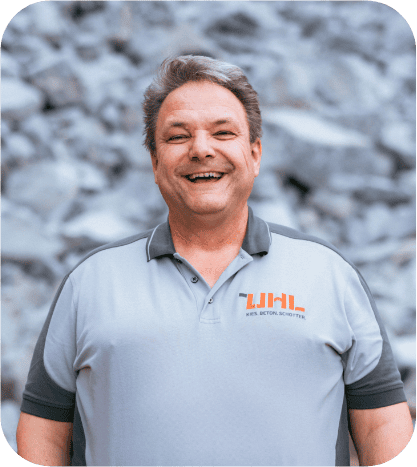 Glücklicher Mann im grauen Arbeitspoloshirt, LHL Beton Schotter-Logo. Karriere