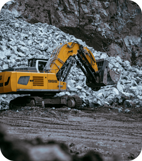 Gelber Bagger gräbt Steine in einem Steinbruch