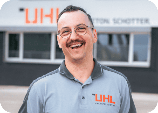 Glücklicher Mann im UHL-Poloshirt, Kies, Beton, Schotter