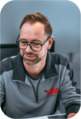 Freundlicher Mann mit Brille und grauer LHV-Arbeitsjacke