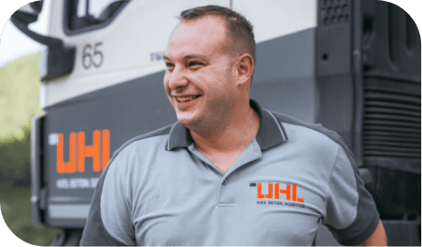 Glücklicher UHL-Mitarbeiter steht neben einem LKW