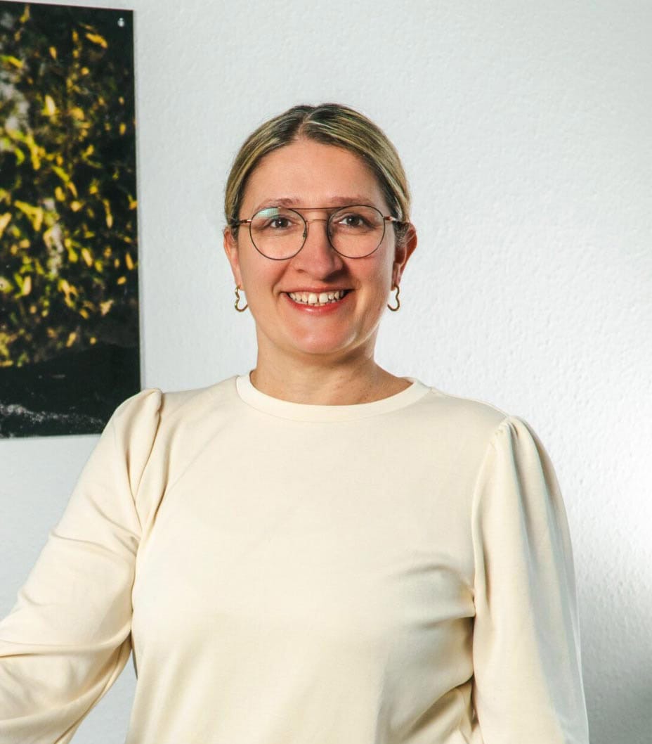 Lächelnde Frau mit Brille, bereit für ihre Ausbildung.