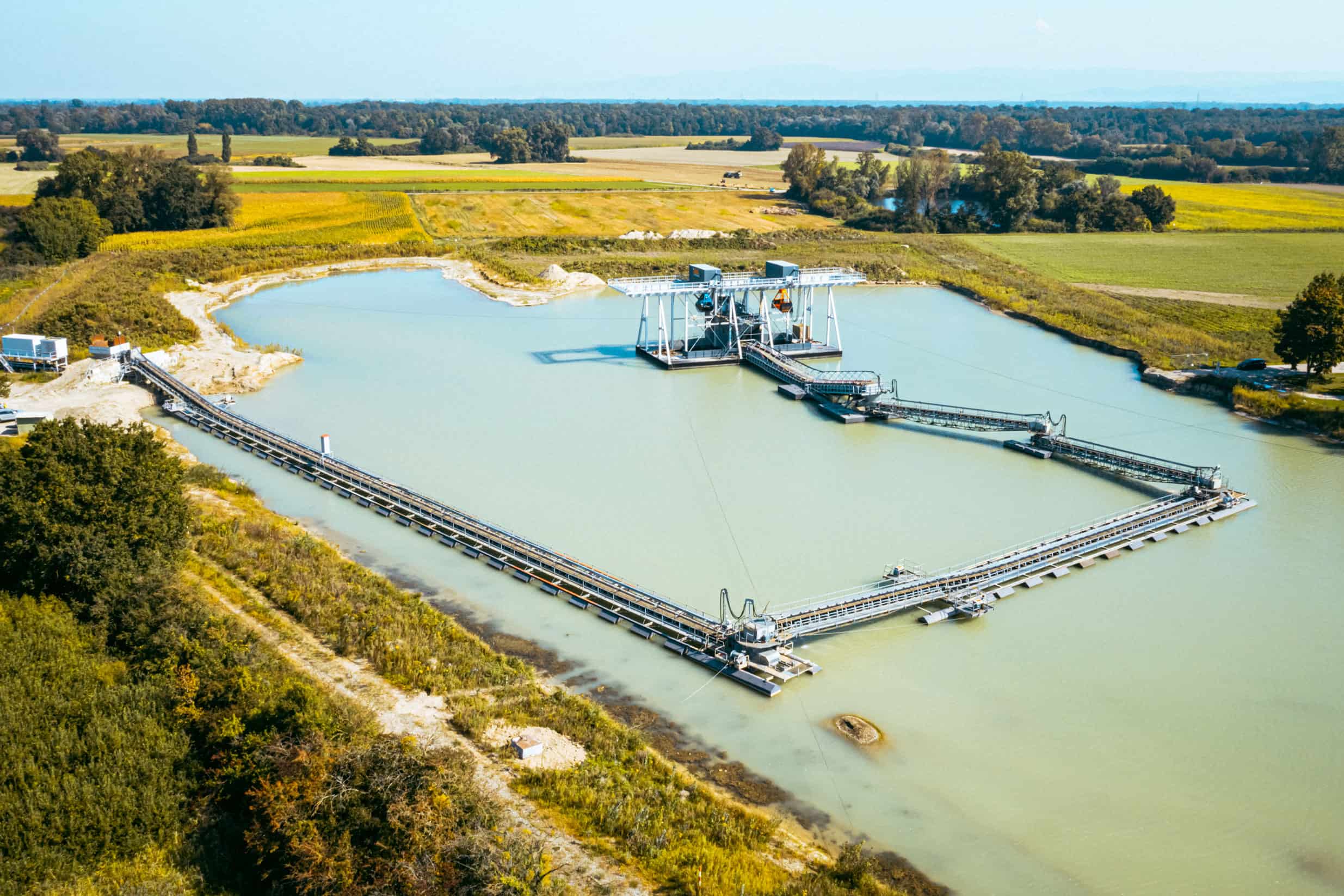 Luftaufnahme eines schwimmenden Förderbandsystems, das in einem Sand- und Kiessteinbruch verwendet wird.